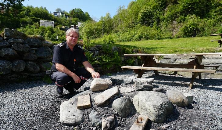 Brannsjef Stein Gjøsund ved bålplassen i Mobergsvikjo. Den kan du ikkje nytte no når det er forbod mot eld i skog og mark, men heime på terrassen kan du framleis grille (foto: Andris Hamre)