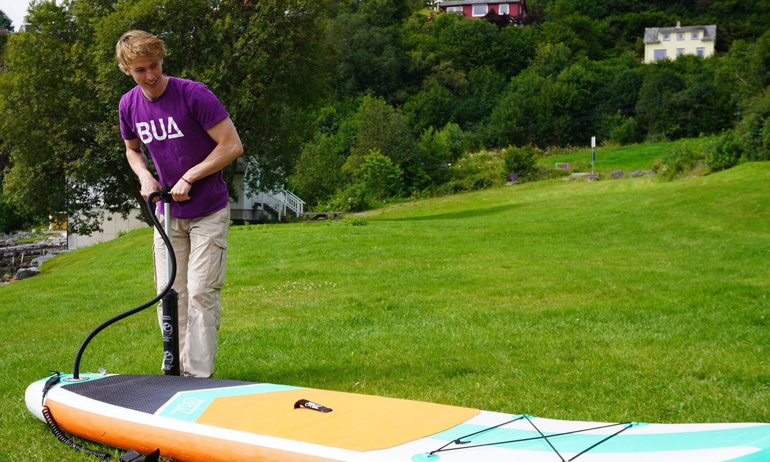 Torstein Haugetun (21) i sving med å pumpa opp SUP-ane. (Foto: Elin Johnsen)