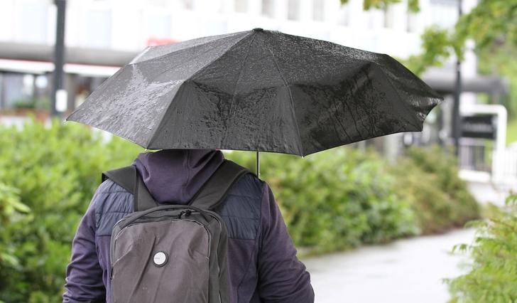 Det var paraplyvêr i Os sentrum måndag formiddag. (Foto: Kjetil Vasby Bruarøy)